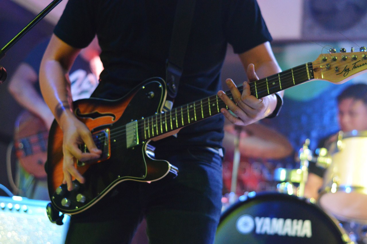 A guitarist playing an electric guitar on stage